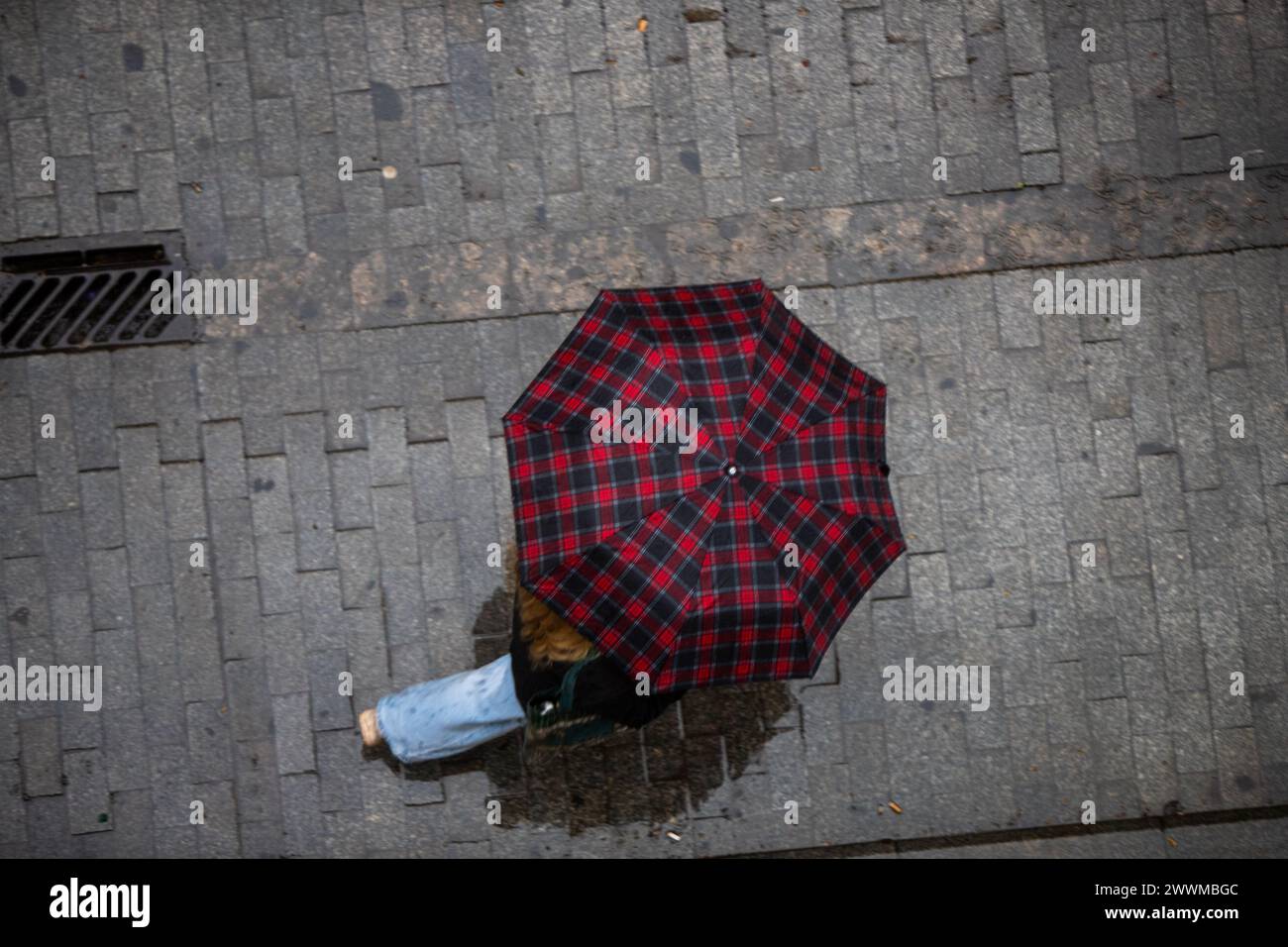 Aerial view of a person walking with an umbrella on a rainy day Stock Photo