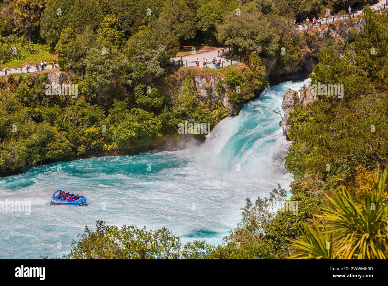 A group of people standing and looking on a Jet boat at the Huka Falls, a set of waterfalls on the Waikato River, which drains Lake Taupo, on the Nort Stock Photo
