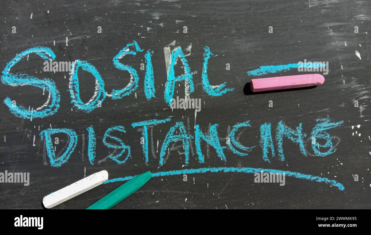 "Social Distancing" text on a black and crayon background Stock Photo