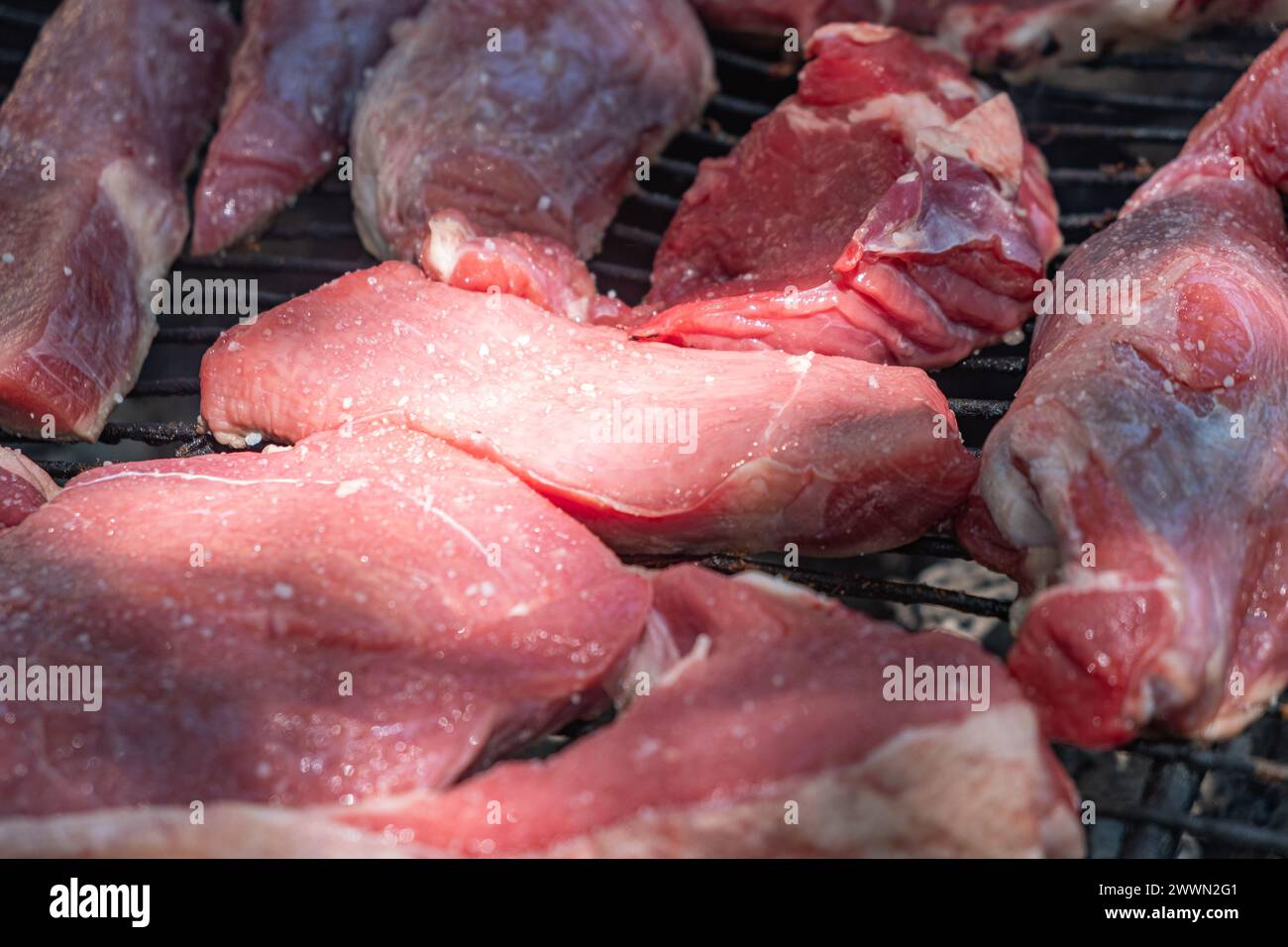 Grilling outdoor. Detail view of cow meat in the charcoal grill Stock