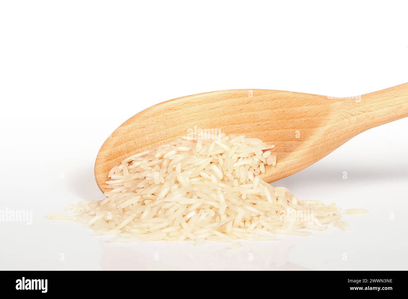wooden spoon with rice on white background close up Stock Photo