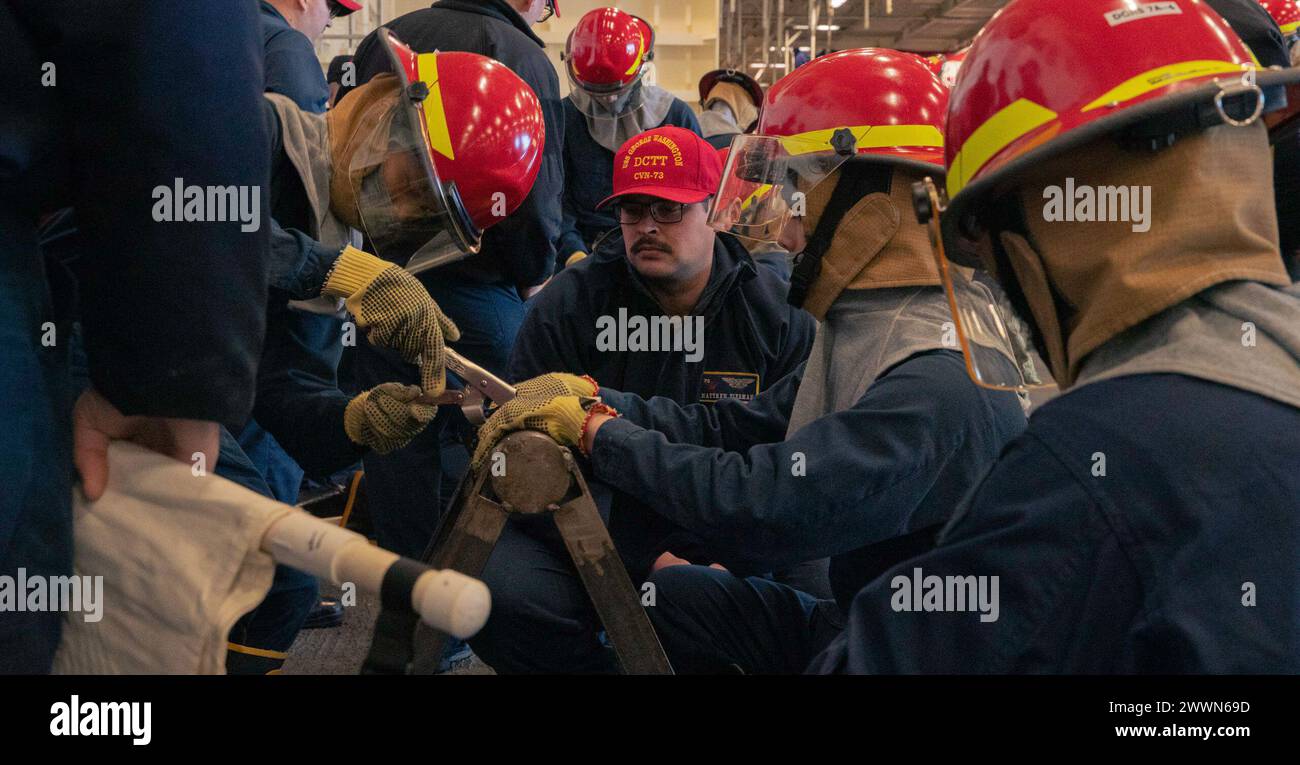 Patching Crew Sailors conduct pipe patching drills in the hangar bay of Nimitz-class ...