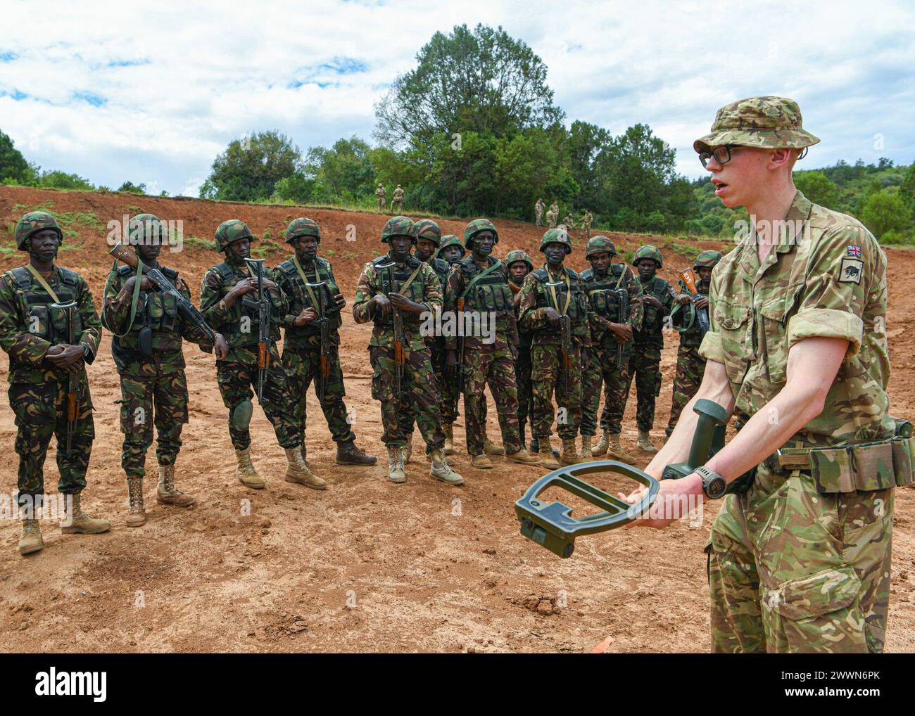 British army Drummer Todd Yates, assigned to 1st Battalion Irish Guards, 11th Security Force Assistance Brigade, British Army, demonstrates how to assemble a mine detector to Kenya Defence Forces soldiers during counter improvised explosive devices training at Justified Accord 2024 (JA24) held at the Counter Insurgency Terrorism and Stability Training Centre, Nanyuki, Kenya, February 26, 2024. JA24 is U.S. Africa Command's largest exercise in East Africa, running from February 26 - March 7. Led by U.S. Army Southern European Task Force, Africa (SETAF-AF), and hosted in Kenya, this year's exerc Stock Photo