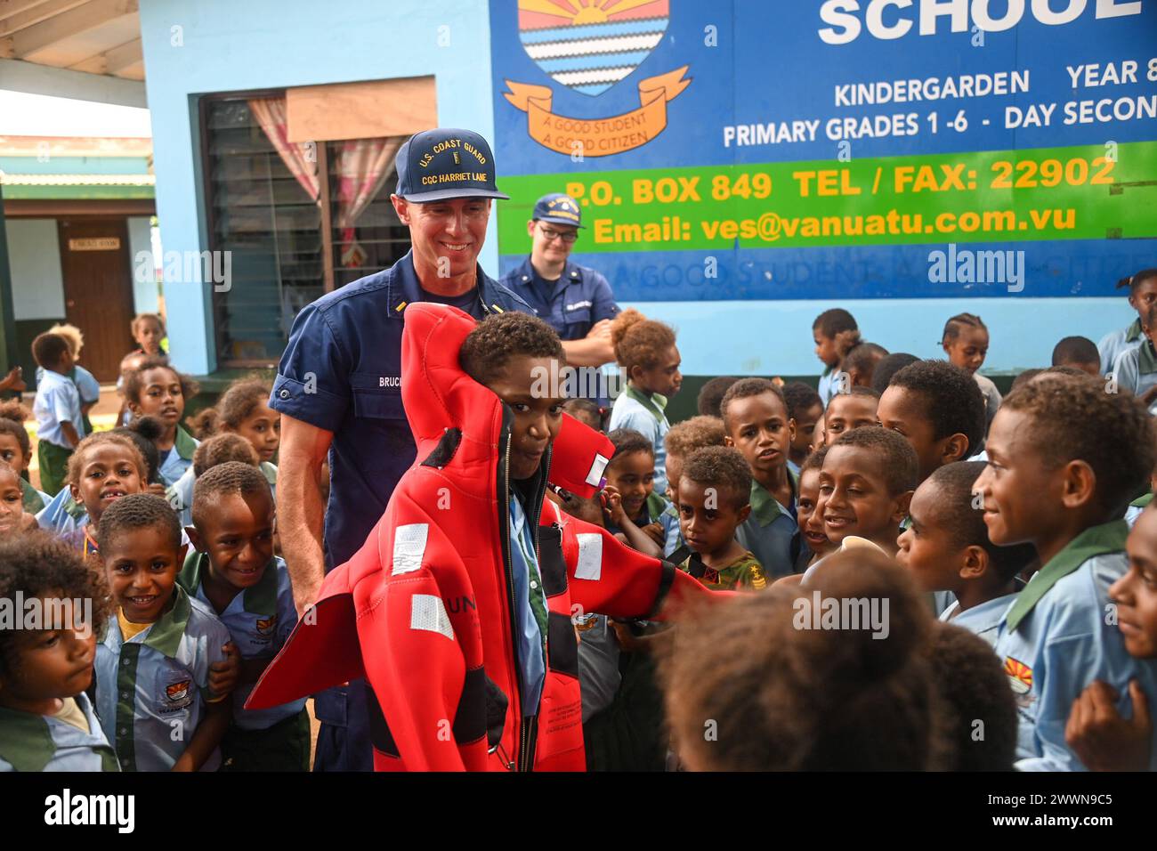 U.S. Coast Guard Ensign Tyler Bruch, a U.S. Coast Guard Cutter Harriet Lane (WMEC 903) crew member, helps a Vila East school boy into a gumby suit in Port Vila, Vanuatu, Feb. 29, 2024. Harriet Lane crew members visited two schools in Port Vila to strengthen ties with the local community and share cultural knowledge between the two countries.  Coast Guard Stock Photo
