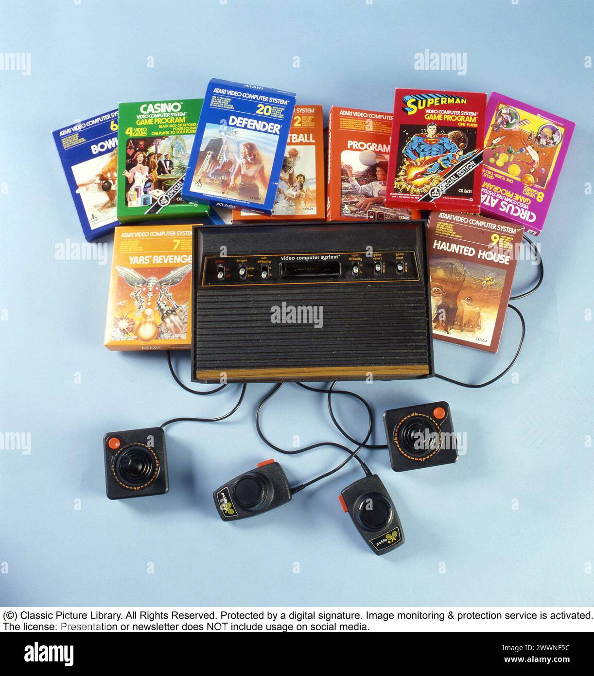 Home video games in the 1980s. In the 1970s and 1980s Atari was one of the leading manufacturers of videogames and produced game consols and at home computers. Pictured a Atari game consol and games in their original packaging. 1982. Stock Photo