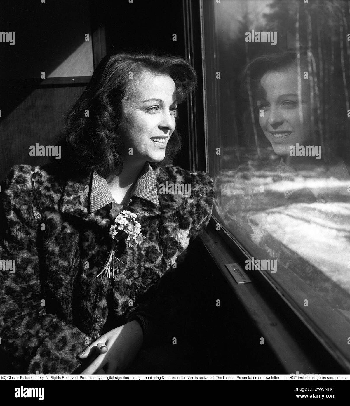 Gunnel Broström. 1921-2012. Swedish actress. She appeared in around thirty films during her career. Photographed during a train journey as she looks out the window with her own reflection visible. 1946. Kristoffersson ref T34-4 Stock Photo