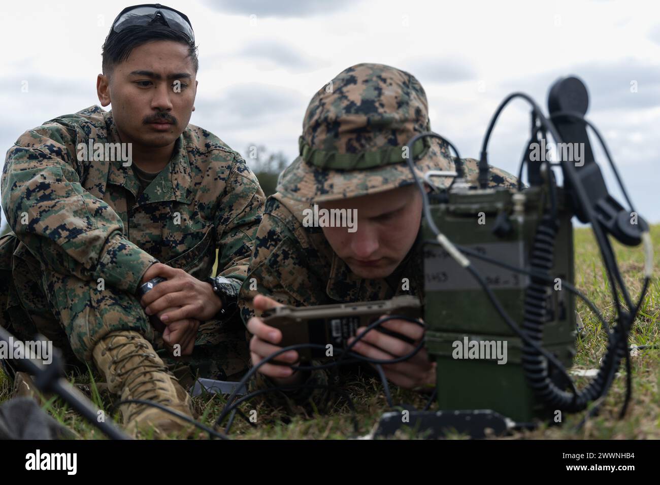 U.S. Marines Lance Cpl. Christian Montemayor, a fire support Marine, left, and Sgt. John Philips a transmissions system operator, right, both with 5th Air Naval Gunfire Liaison Company, III Marine Expeditionary Force Information Group, conduct a communications check during a field exercise, Rapid Tanto at Ie Shima, Okinawa, Japan, Feb. 6, 2024. The radio allowed transmission of data to higher headquarters. Using off-the-shelf radars and low-signature equipment, 5th ANGLICO and 3rd Intelligence Battalion demonstrated proficiency in planning, coordination, and execution of dynamic targeting capa Stock Photo