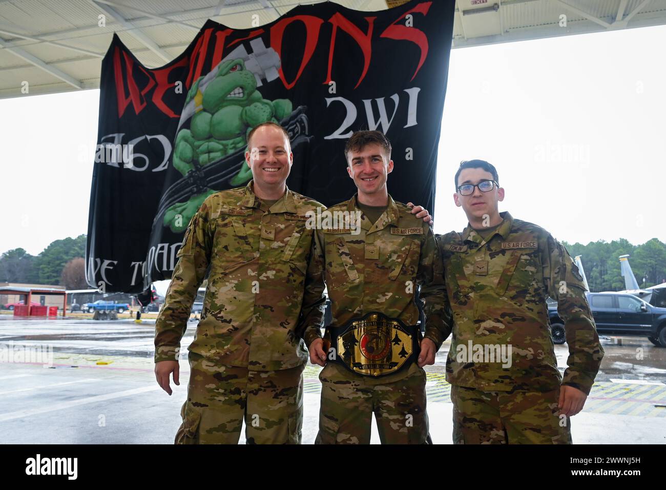 U.S. Air Force Senior Airman Tyler Grubbs, left, Airman Aiden Albritton, and Airman 1st Class Seth Tomlin, right, all assisted dedicated crew chiefs assigned to the 333rd Fighter Generation Squadron, pose for a photo after winning 1st place at an annual load crew competition at Seymour Johnson Air Force Base, North Carolina, on February 23, 2024.  Air Force Stock Photo