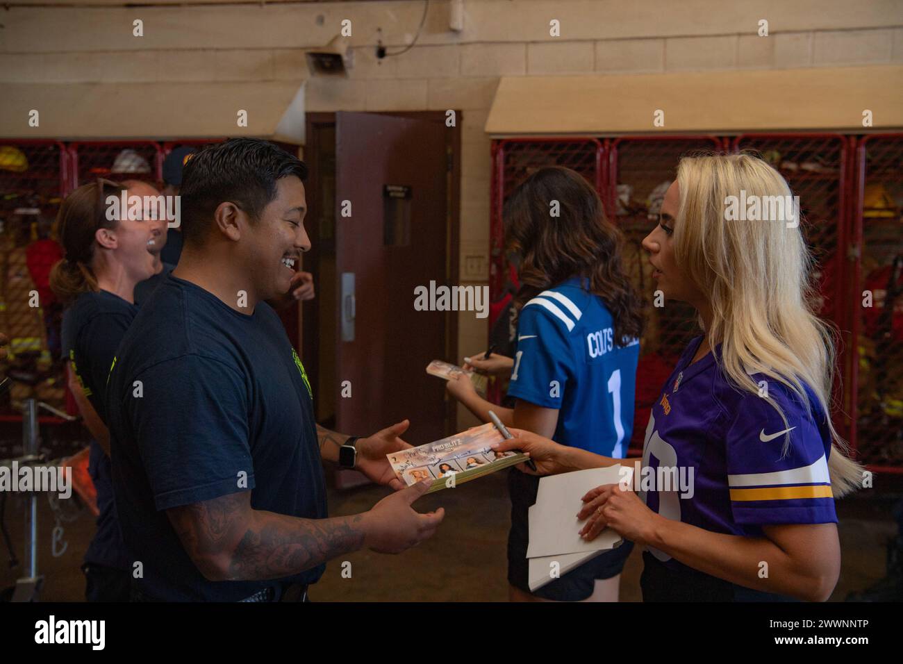 KEKAHA, Hawaii (Feb. 5, 2024) National Football League cheerleaders Whitney of the Minnesota Vikings and Hannah of the Indianapolis Colts  talk to fire fighters from Barking Sands Fire and Emergency Services as part of the Armed Forces Entertainment Pro Blitz Tour 24 on Pacific Missile Range Facilities, Barking Sands, Kekaha, Hawaii. Armed Forces Entertainment provides performances for U.S. troops and family members stationed overseas; over the last 70 years, AFE has served as a morale booster for U.S. troops on military bases around the world, the Department of Defense has made entertainment Stock Photo