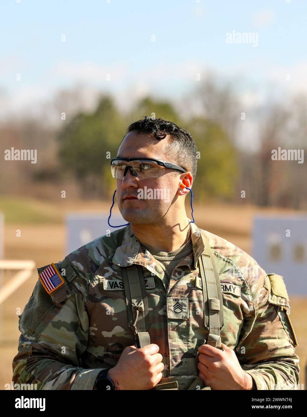 Tennessee Army National Guardsman Staff Sgt. Daniel Vasquez, from the 30th Troop Command, waits for others to adjust their close combat optics at the zero range during the Tennessee State Best Warrior Competition in Tullahoma, Feb. 23, 2024. All competitors zeroed their M-4 weapons prior to continuing with a series of battle stations.  Army National Guard Stock Photo