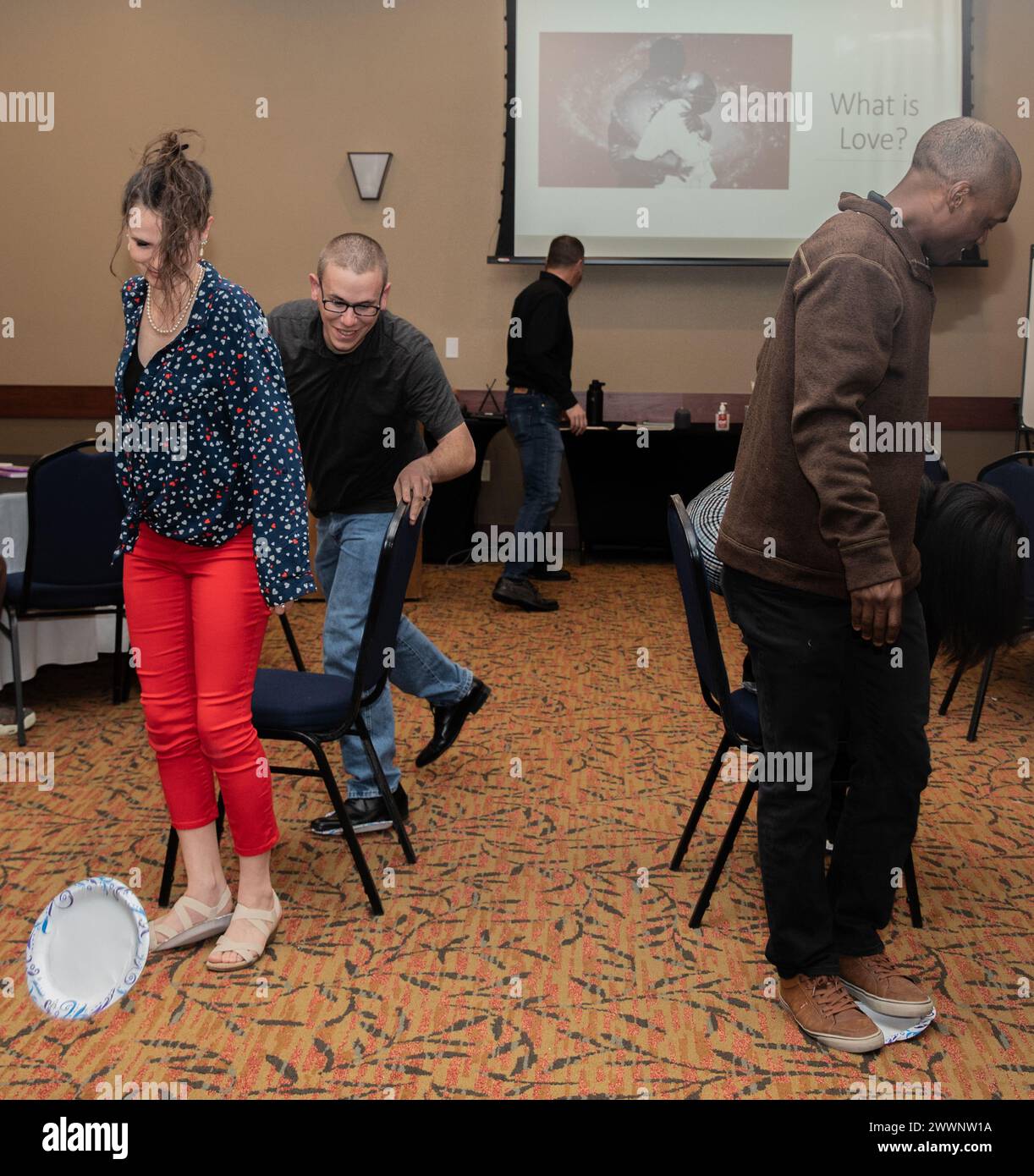 Soldiers assigned to 68th Division Sustainment Support Battalion, 4th Division Sustainment Brigade, and their spouses participate in a team building exercise during a Building Strong and Ready Team event at the Great Wolf Lodge, in Colorado Spring, Colo., Feb. 15, 2024. The challenge was for the couples to cross the room using the paper plates as steppingstones and in the process foster teamwork and communication. ( Stock Photo