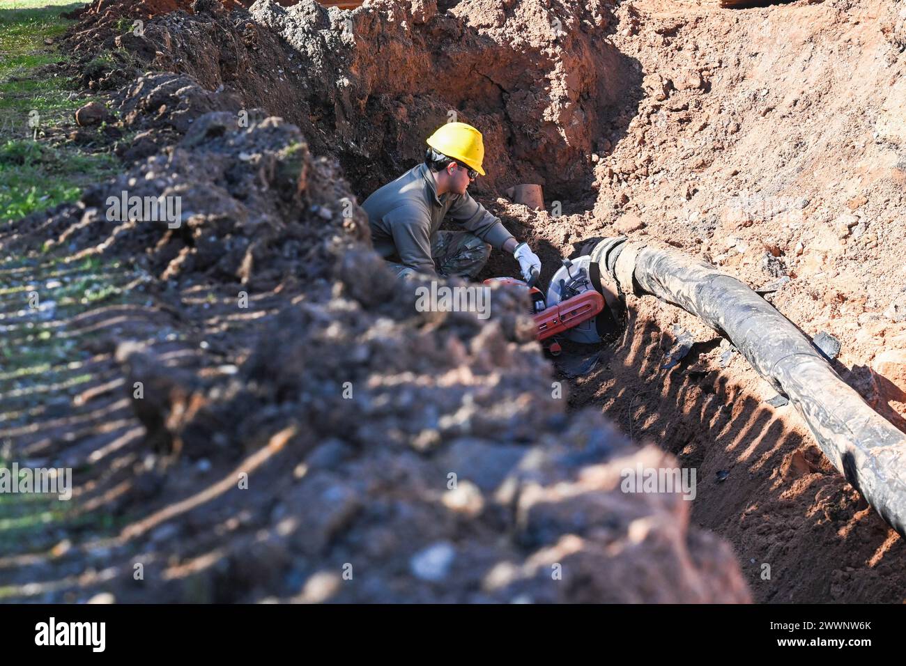 Airman 1st Class Jose Vargas, 2nd Civil Engineer Squadron water and fuels system maintenance apprentice, focuses while he cuts through a pipe Feb. 6, 2024 at Barksdale Air Force Base, La. Vargas cut through the pipe in order to remove it from the ditch and identify the problem with his team.  Air Force Stock Photo