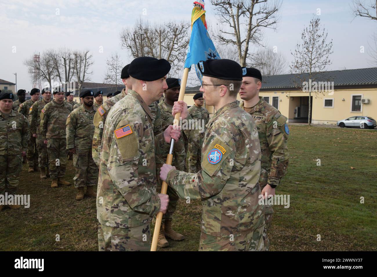 U.S. Army incoming commander Capt. Thor J. Rushing, Company B commander, left, receives the guidon from Lt. Col. John G. Wildt, right, commander of 307th Military Intelligence Brigade, during the change of command ceremony for Bravo Company, 307th Military Intelligence at Caserma Ederle in Vicenza, Italy, Feb.. 16, 2024.  Army Stock Photo