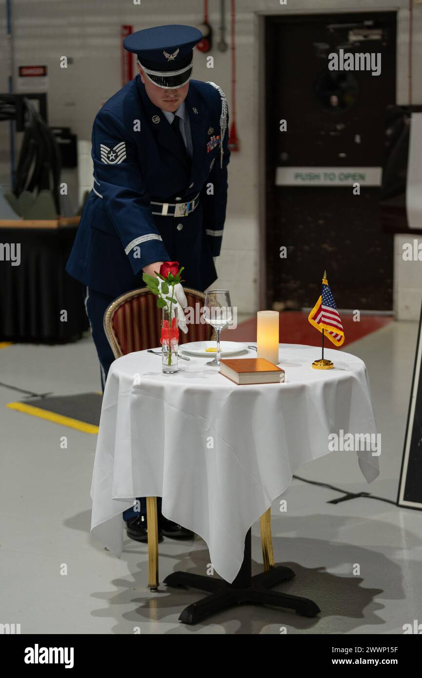 U.S. Air Force Tech. Sgt. Cody Salzman, First Term Enlisted Center noncommissioned officer, points at an item as it is being described on the Prisoner of War/Missing in Action remembrance table during the 100th Air Refueling Wing annual award ceremony at Royal Air Force Mildenhall, Feb. 23, 2024. The POW/MIA table serves to honor service members who came before and are unable to attend an event due to their status as a POW or MIA.  Air Force Stock Photo