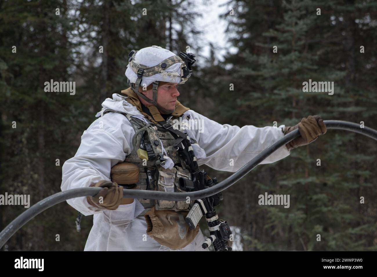 A U.S. Soldier, assigned to 1st Battalion, 24th Infantry Regiment, 1st Infantry Brigade Combat Team, 11th Airborne Division, helps set up electricity for communication during Joint Pacific Multinational Readiness Center 24-02 at Donnelly Training Area, Alaska, Feb. 19, 2024. JPMRC 24-02, executed in Alaska with its world-class training facilities and its harsh Arctic environment, builds Soldiers and leaders into a cohesive team of skilled, tough, alert, and adaptive warriors capable of fighting and winning anywhere in the world.  Army Stock Photo