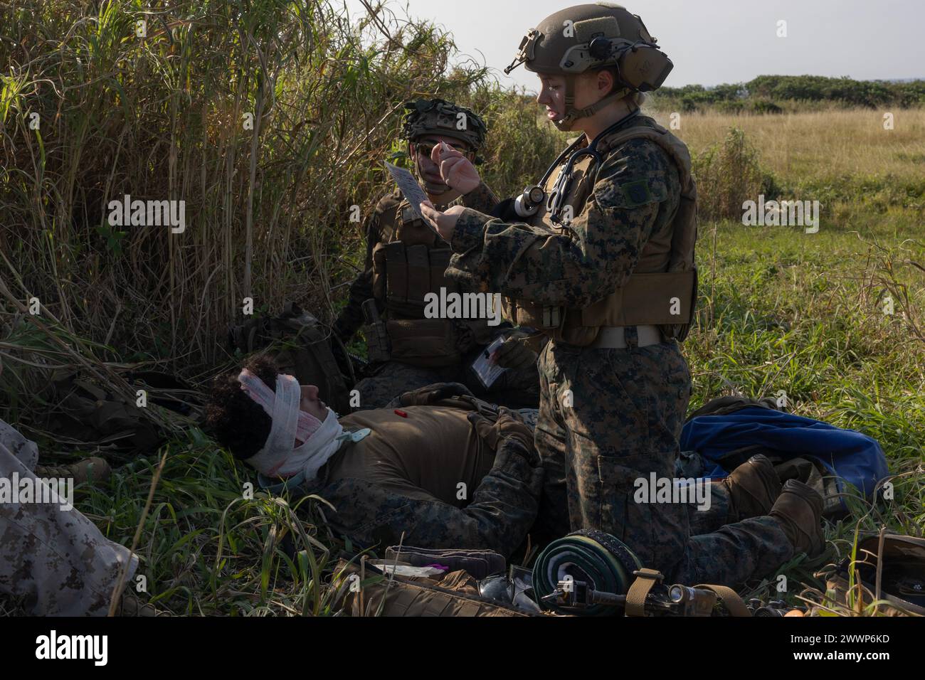 U.S. Navy hospital corpsman third class Savannah Nix, with Battalion Landing Team 1/1, 31st Marine Expeditionary Unit, gives medical care to a simulated casualty during a helicopter raid exercise on Ie Shima, Okinawa, Japan, Feb. 13, 2024. The exercise simulated taking control of an enemy airfield and supporting further denial operations. The 31st MEU is operating aboard ships of the America Amphibious Ready Group in the 7th Fleet area of operations, the U.S. Navy’s largest forward-deployed numbered fleet, and routinely interacts and operates with allies and partners in preserving a free and o Stock Photo