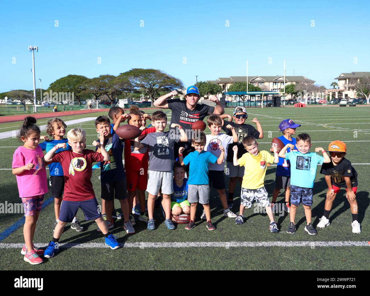 NFL football player Cameron “Dicker the Kicker” Dicker, placekicker for the Los Angeles Chargers, and children pose for a group photo during the Armed Forces Entertainment’s Pro Blitz Tour 2024 at Marine Corps Base Hawaii, Feb. 8, 2024. The visit provided service members and their families the opportunity to meet retired and current NFL cheerleaders and Football Hall of Fame Honorees.  Marine Corps Stock Photo