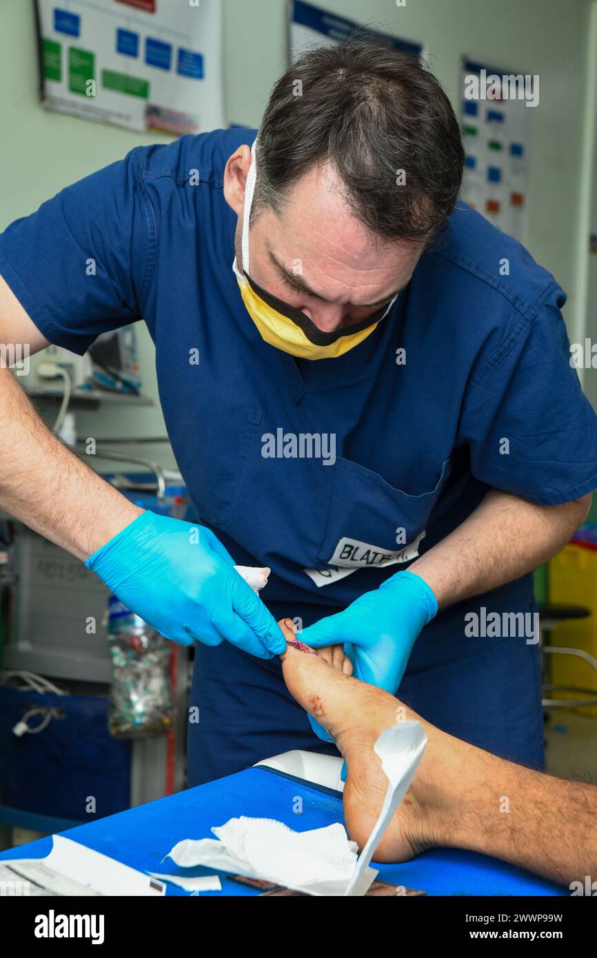 240222-N-FB730-1126 SAN PEDRO SULA, HONDURAS (Feb. 22, 2024) Hospital Corpsman 1st Class Blair Hess, Expeditionary Medical Facility (EMF) platform operational training manager with Naval Medical Forces Atlantic, cleans a patient injury in the trauma bay at Hospital Mario Catarino Rivas, San Pedro Sula, Honduras, on Feb. 22, 2024 In collaboration with joint forces and the host nation, EMF-Kilo conducted its first Global Health Engagement to enhance expeditionary core skills and knowledge exchange with Honduran health care professionals in a limited resource environment.  Navy Stock Photo