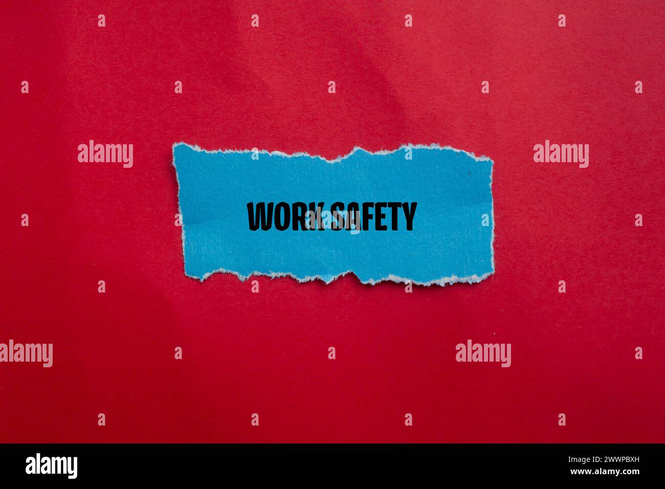 Work safety words written on blue torn paper piece with red background. Conceptual symbol. Copy space. Stock Photo