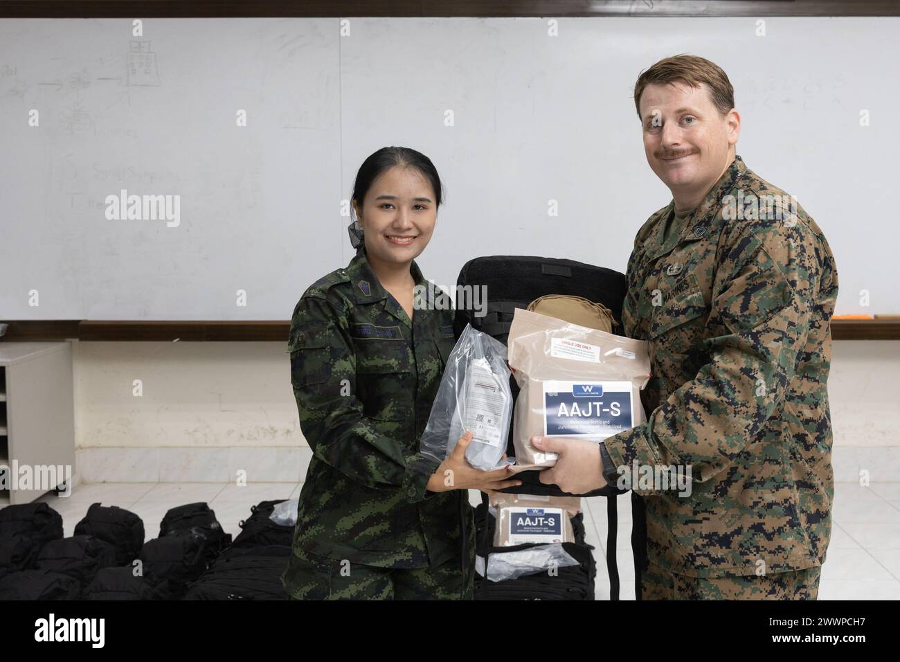 U.S. Marine Corps Gunnery Sgt. Pierce Draper, right, the Humanitarian Mine Action (HMA) Thailand team leader with Explosive Ordnance Disposal (EOD) Company, 9th Engineer Support Battalion, 3rd Marine Logistics Group, presents medical supplies to Royal Thai Army Lt. Wasinee Theerawong, a nurse with Fort Weerawat Yothin Hospital, during a landmine casualty care (LCC) course graduation at Fort Bhanurangsi, Ratchaburi, Thailand, Feb. 2, 2024. Graduates of the LCC course received donations of medical equipment from the U.S. Marine Corps Forces, Pacific HMA Program. This equipment will support the H Stock Photo