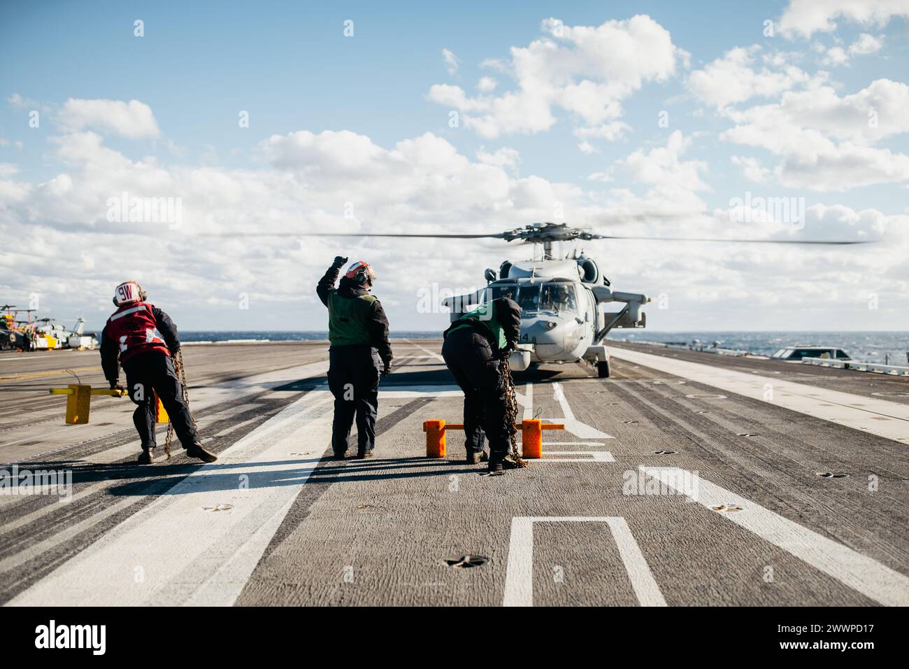 Sailors prepare to launch an MH-60S Seahawk Helicopter off Nimitz-class aircraft carrier USS George Washington (CVN 73) in the Atlantic Ocean Feb. 13, 2024. George Washington is underway in support of future operations.  Navy Stock Photo