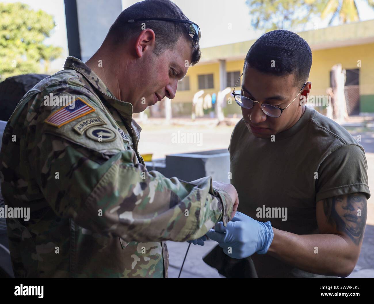 (From left) Warrant Officer Adam Czekalski, an automotive maintenance warrant officer with Joint Force Headquarters, New Hampshire National Guard, explains the levels on the transmission fluid dipstick to Spc. Daniel Bedoya, a mission translator and a wheeled vehicle mechanic with Alpha Company, 1st Battalion, 169th Aviation Regiment (MEDEVAC), 54th Troop Command, New Hampshire Army National Guard, during a troubleshooting exercise with the Fuerza Armada de El Salvador Cavalry mechanics at the Cavalry Regiment base in Sitio del Nino, El Salvador on February 16, 2024.  Army National Guard Stock Photo