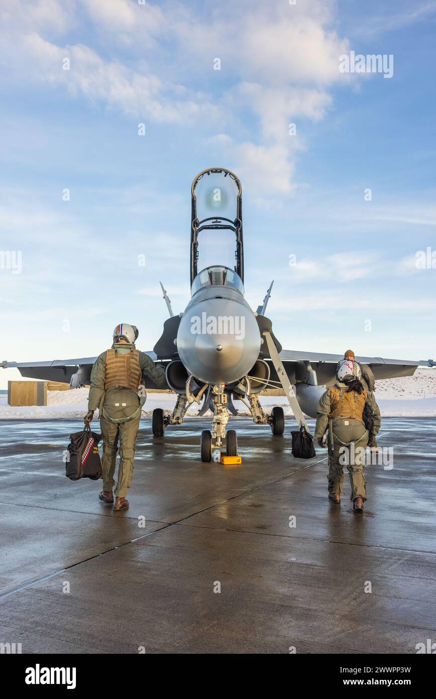 U.S. Marine Corps Maj. Matthew Andrews, left, a native of Wisconsin and an F/A-18 pilot, and Capt. Heather Hamilton, right, a native of New Jersey and a weapons system officer, both with Marine Fighter Attack Squadron (VMFA) 312, 2nd Marine Aircraft Wing, inspect an F/A-18D Hornet before conducting routine flight operations in preparation for Exercise Nordic Response 24 at Andenes, Norway, Feb. 23, 2024. Exercise Nordic Response, formerly known as Cold Response, is a NATO training event conducted every two years to promote military competency in arctic environments and to foster interoperabili Stock Photo