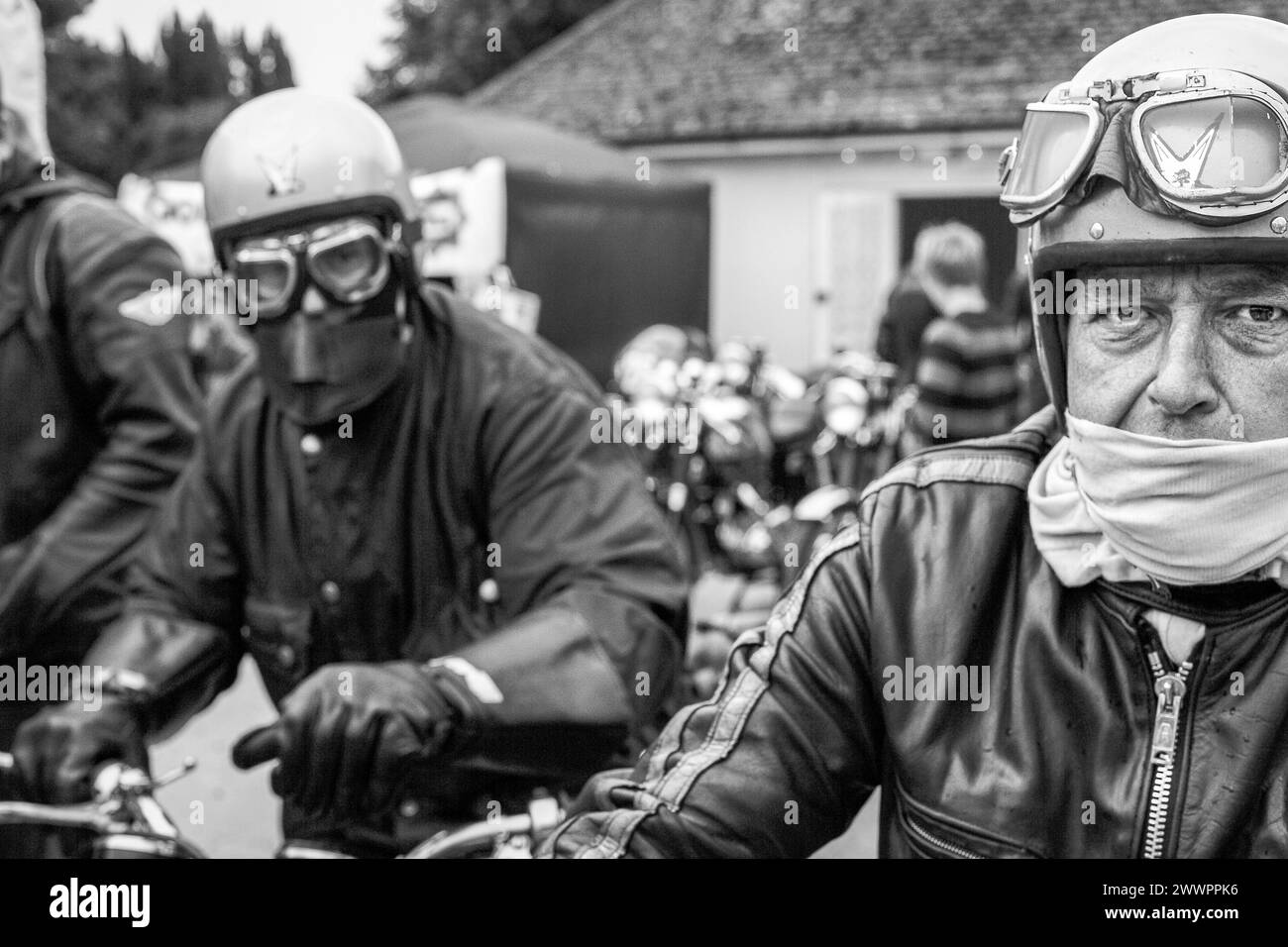 two motorcyclist motorbiker sitting on motorbikes wearing retro helmet and goggles . Stock Photo