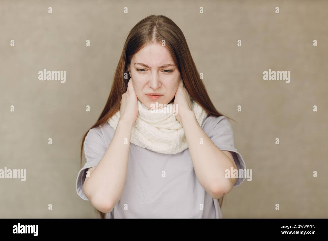 Young woman wearing scarf holds head flu catarrh ill sick disease treatment cold Stock Photo