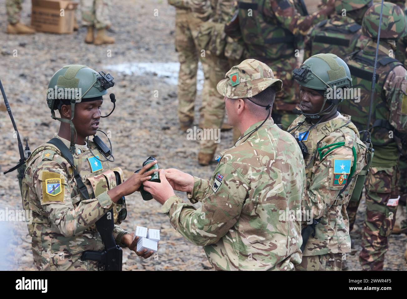 A Somali Danab soldier receives practice munitions from a British Army soldier from the 1st Battalion Irish Guards, 11th Security Forces Brigade during Justified Accord 2024 (JA24) in Nanyuki, Kenya, Feb. 28, 2024. JA24 is U.S. Africa Command's largest exercise in East Africa, running from Feb. 26 - March 7. Led by U.S. Army Southern European Task Force, Africa (SETAF-AF), and hosted in Kenya, this year's exercise will incorporate personnel and units from 23 nations. This multinational exercise builds readiness for the U.S. joint force, prepares regional partners for UN and AU mandated mission Stock Photo