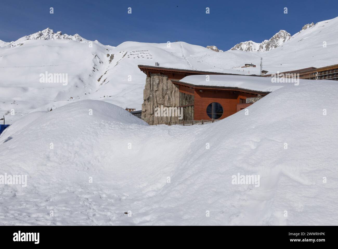 The Lagon swimming pool and leisure centre by DHA architecte at the French Alpine ski-resort of Tignes seems to be rising up from a snow drift. Stock Photo
