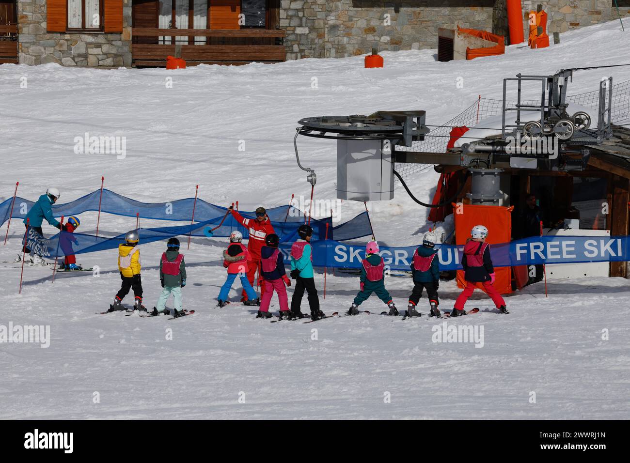 Children learning to ski listen to their instructor at the button lift for the beginner's slope in the Lavachet district of Tignes in the French Alps. Stock Photo