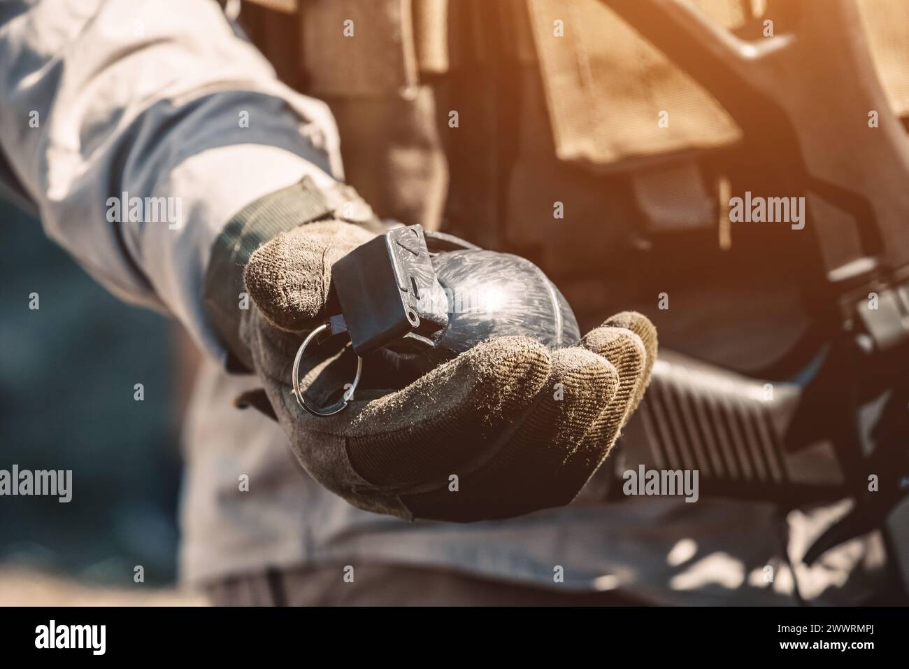 The soldier holds in his hand a training grenade while passing military exercises in the army. Stock Photo