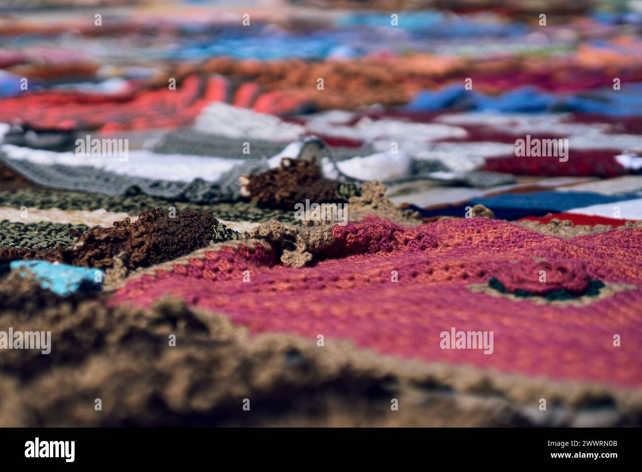 Assorted red, white, and blue blankets stacked on ground Stock Photo