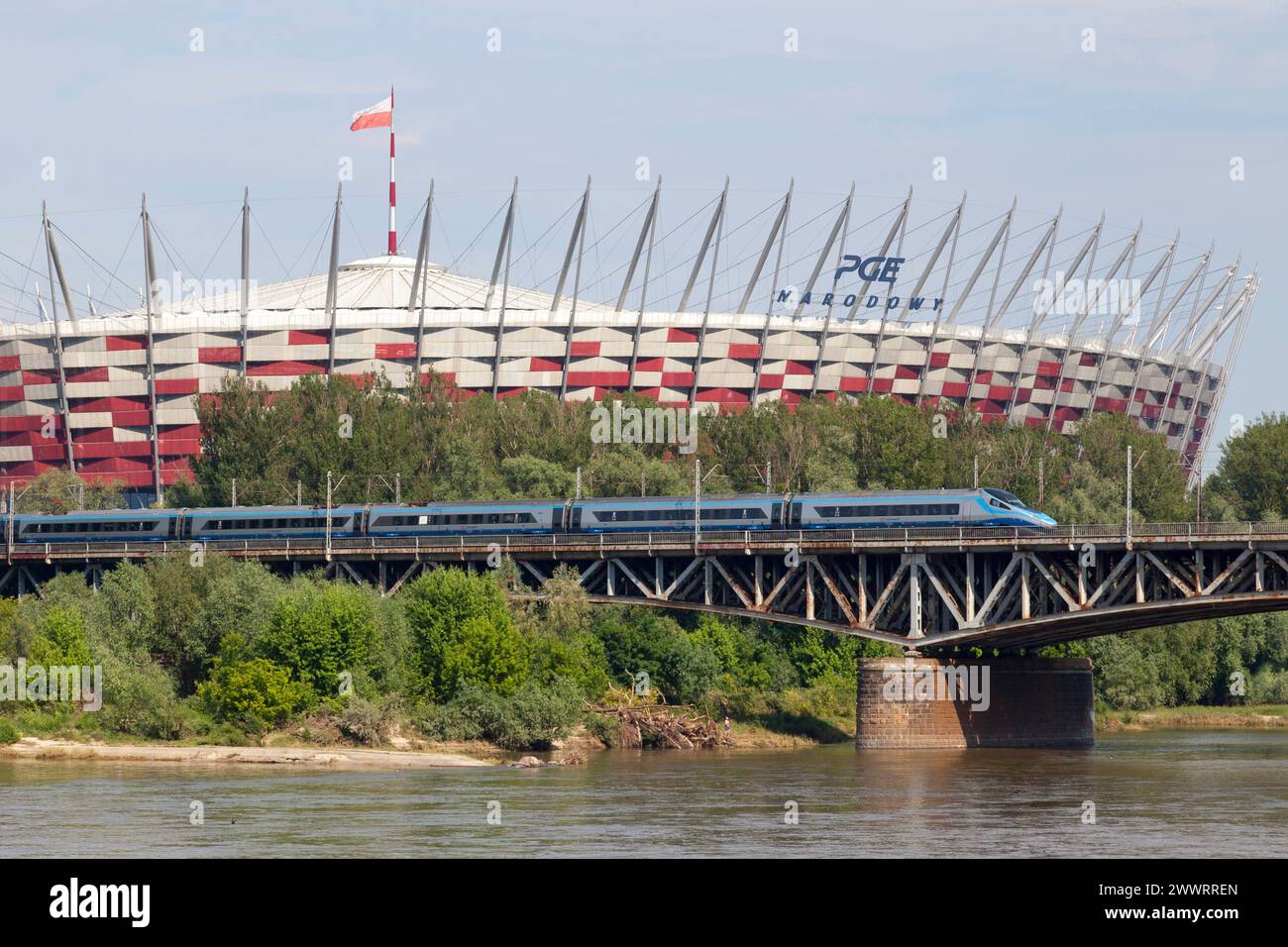 Warsaw, Poland - June 08 2019: A PKP Intercity ED250 Pendolino high-speed train crossing the Średnicowy Bridge over the Vistula River with behind, the Stock Photo