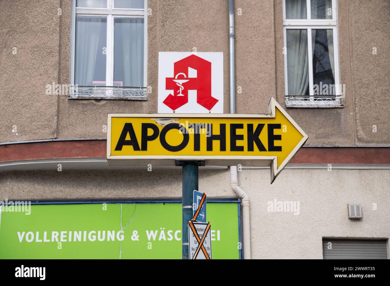 05.03.2024, Berlin, Germany, Europe - Pharmacy sign with red logo and directional arrow in Berlin's district of Charlottenburg-Wilmersdorf. Stock Photo