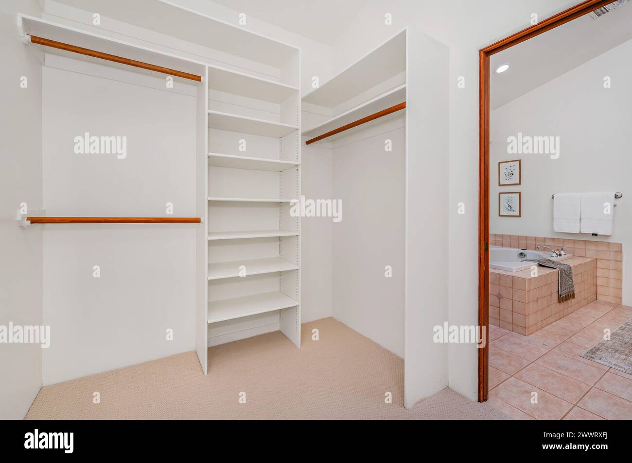 Spacious walk-in closet with shelves and bathtub in a corner Stock Photo