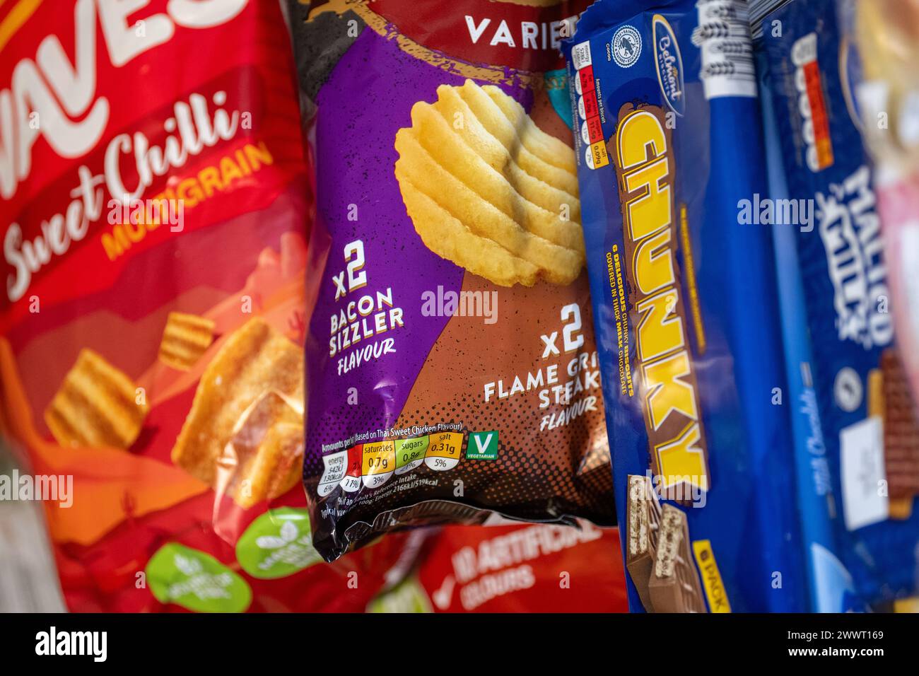 Packets of junk food in a shoppers trolley. UK Stock Photo