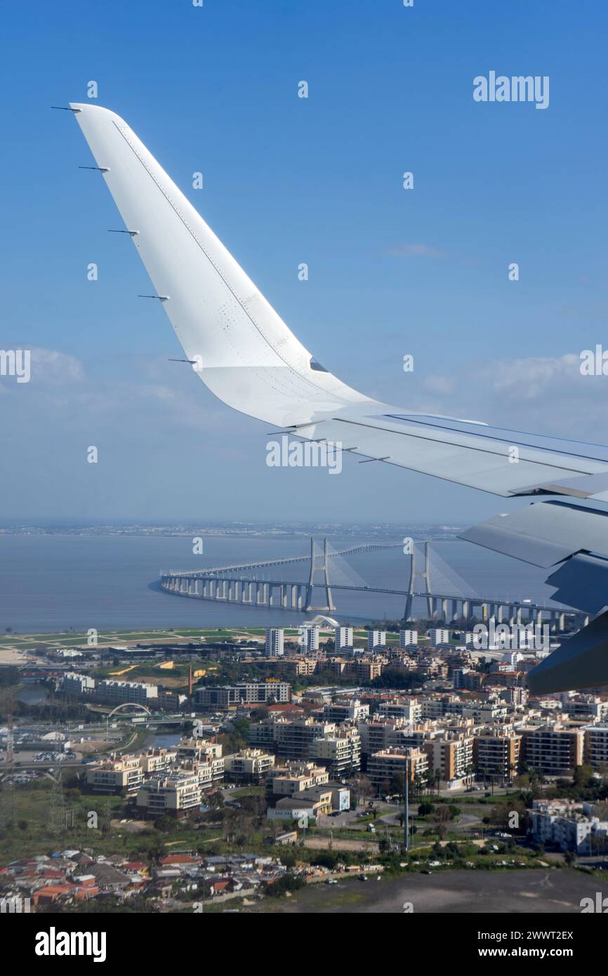 Lisbon, Portugal. March 13, 2024. Aerial view of Vasco da Gama Bridge with airplane wing and Rock in Rio Lisbon 2024 stage in Lisbon, Portugal. Stock Photo
