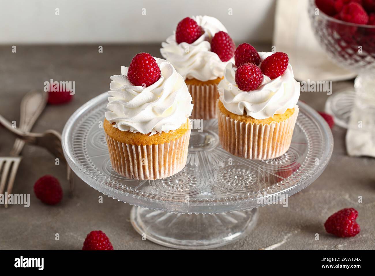 Stand with tasty raspberry cupcakes on table Stock Photo