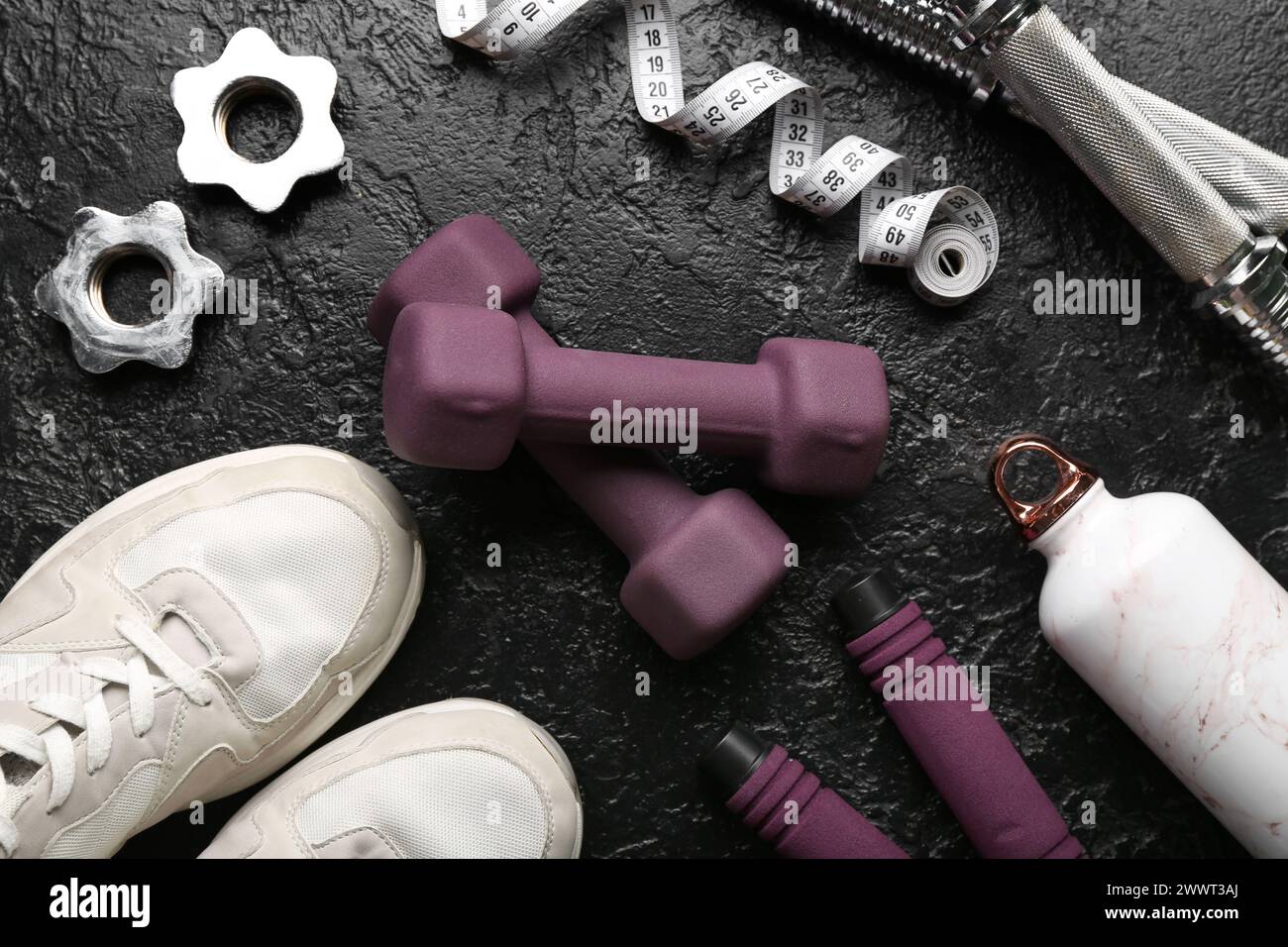 Dumbbells, shoes and measuring tape and clamps on black background Stock Photo