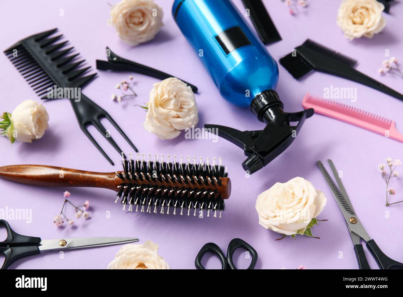 Hairdresser's tools with beautiful roses and gypsophila flowers on