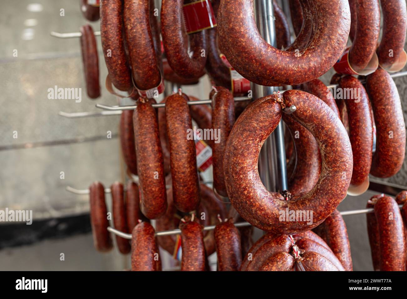 Sausages displayed on the counter for sale in the butcher's shop. Stock Photo