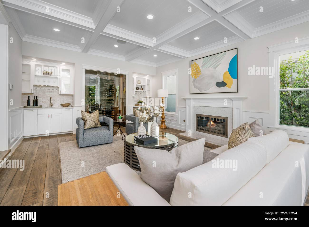 A modern living room with white walls, furniture, and a cozy fireplace ...