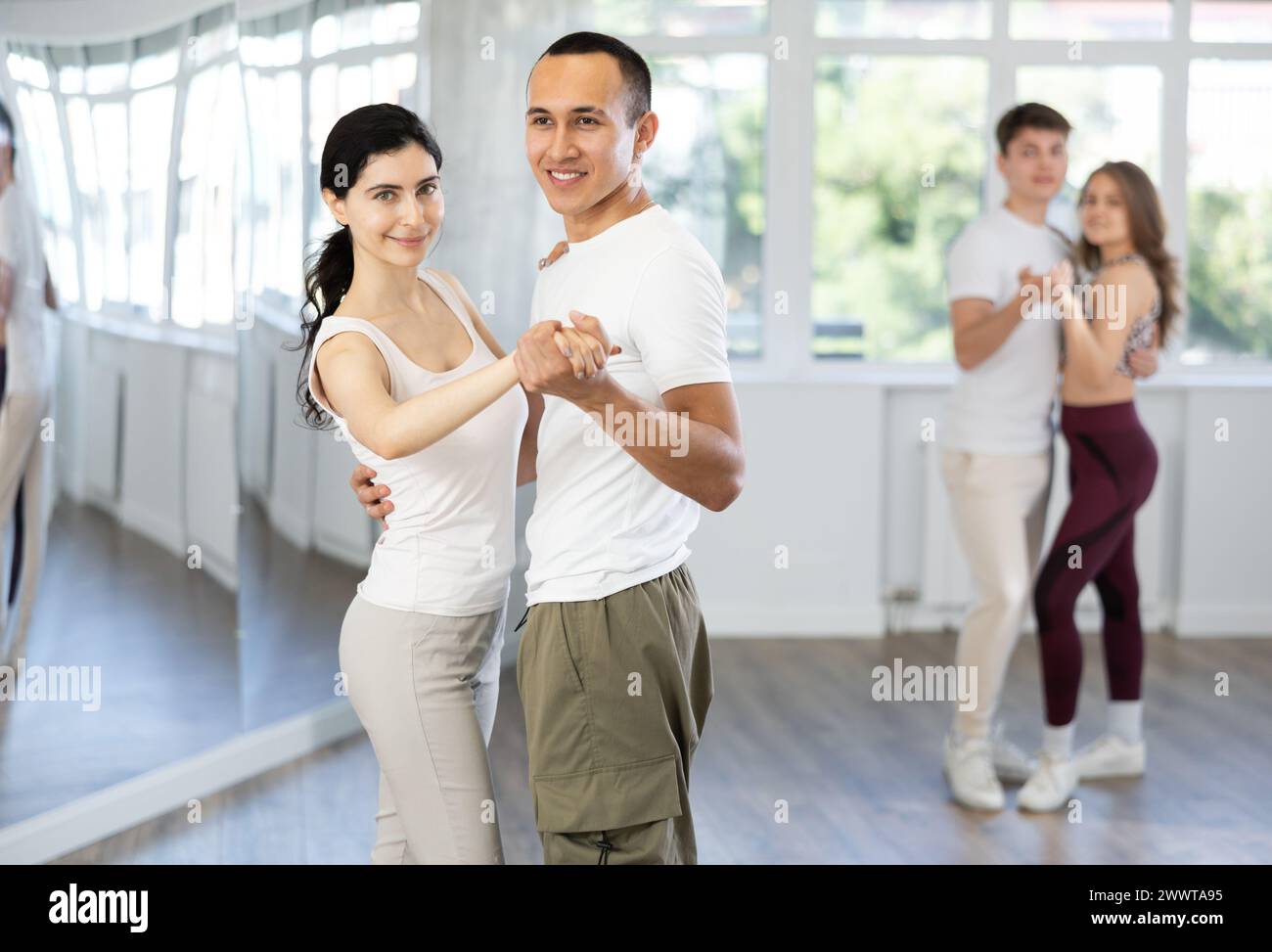 Girl paired up with young man, they train to perform slow waltz dance ...