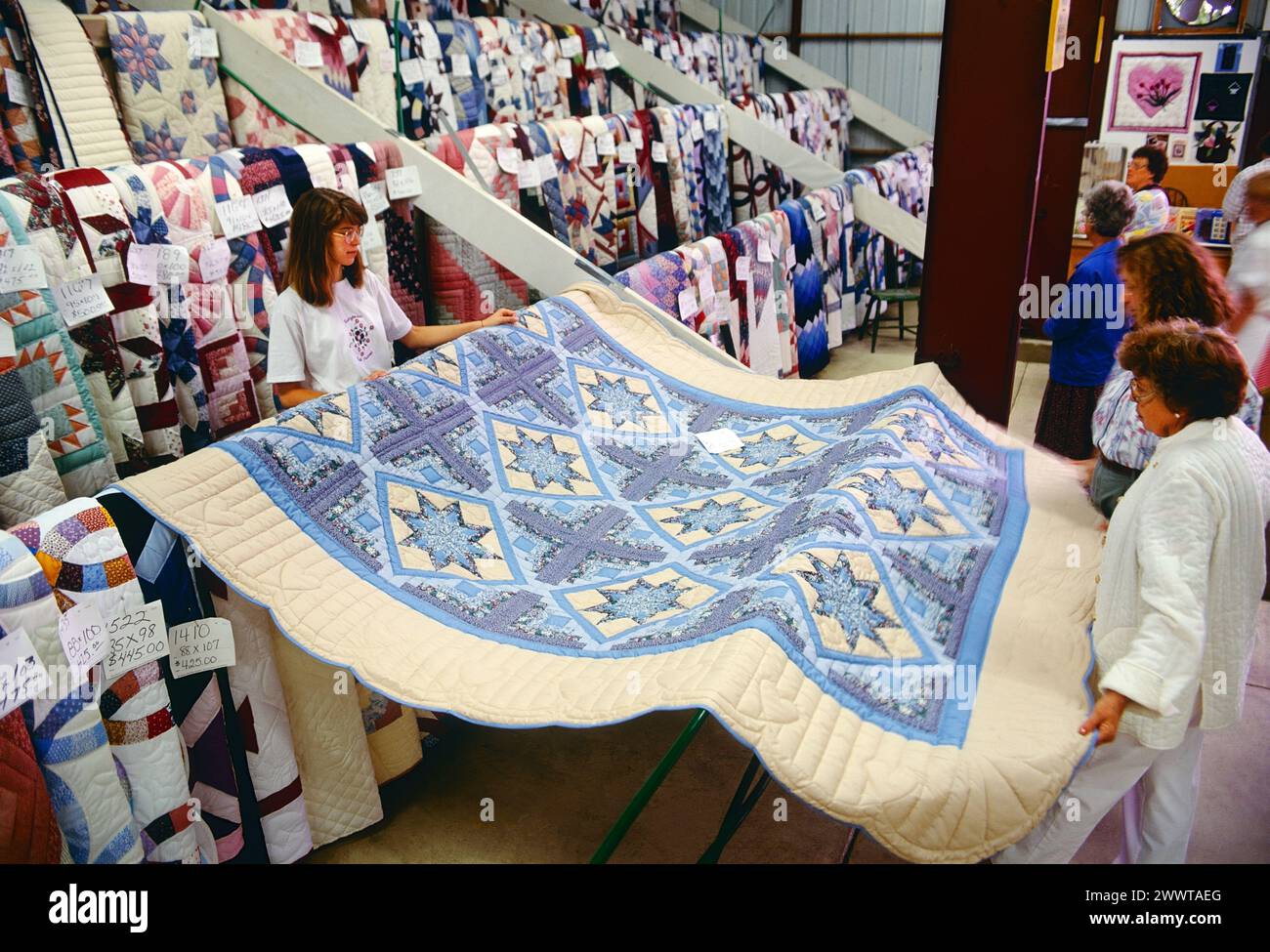 Customers inspect hand made quilts; annual Kutztown Folk Festival; Kutztown; Pennsylvania; USA Stock Photo