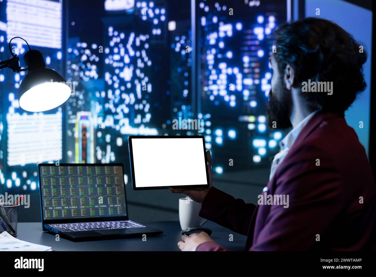 Business investor holding tablet with white screen layout, looking at ...