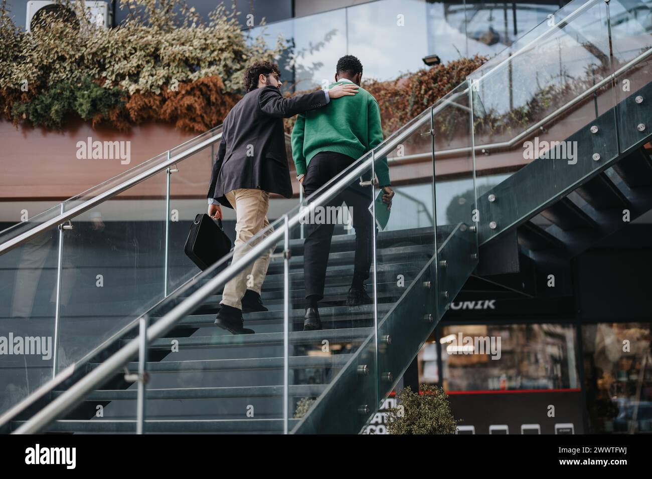 Two men walking up stairs outdoors, engaging in a conversation Stock ...