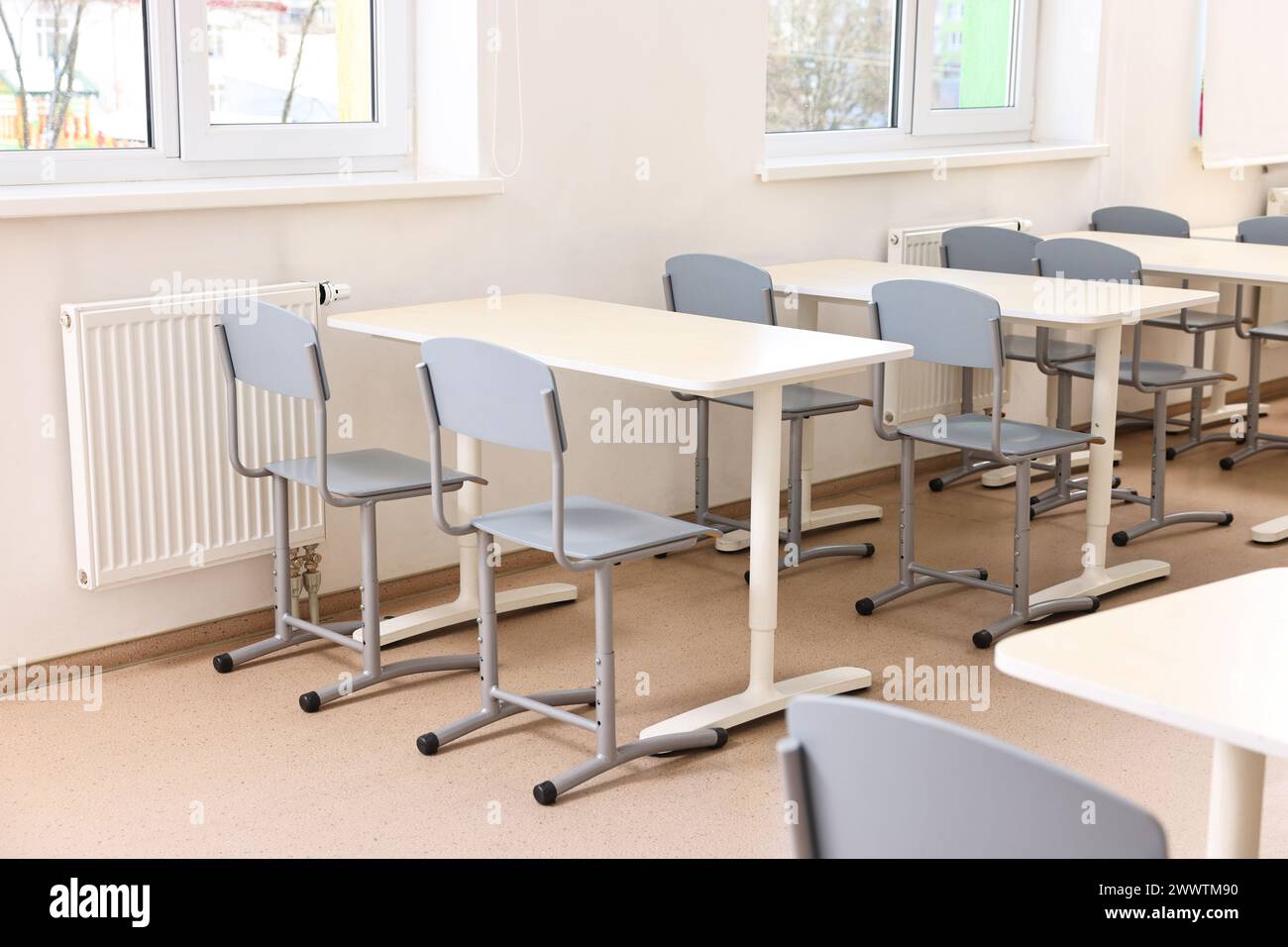 Empty school classroom with desks and chairs Stock Photo