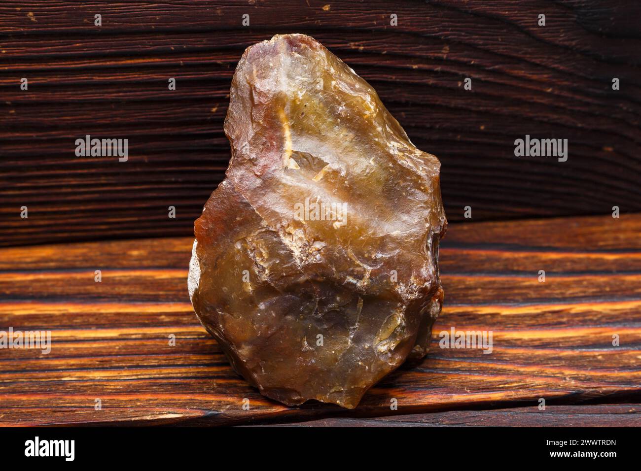 Stone scraper made of red-yellow chalcedony, Stone Age tool Stock Photo